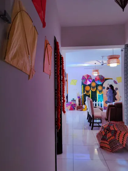 A view of the Lohri celebration setup inside a home. I can transform any space to fit the festive mood, using kites, colorful umbrellas, and traditional elements.