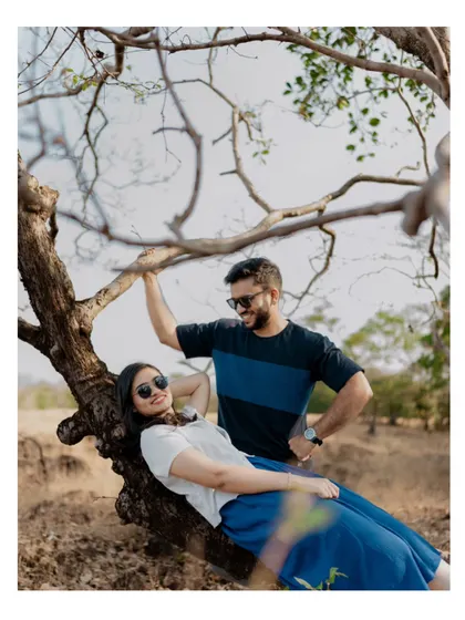 A playful and romantic pose under a tree, capturing the couple's laughter and easy-going connection during their pre-wedding shoot.