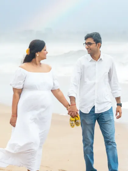 A walk on the beach, hand in hand, with a rainbow gracing the sky. This candid shot from a maternity session in Mumbai captures the magic and hope of this special time. The tiny baby shoes are a sweet touch.