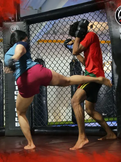 A powerful kick being thrown during a training session. This demonstrates the practical application of Muay Thai techniques we teach, which are vital for self-defense and competition.