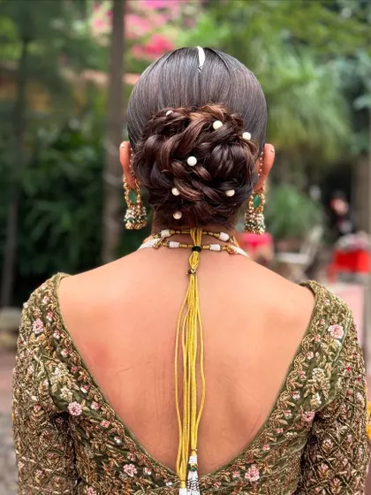 The detail in this pearl-studded messy bun shows how texture can add depth to a bridal hairstyle.
