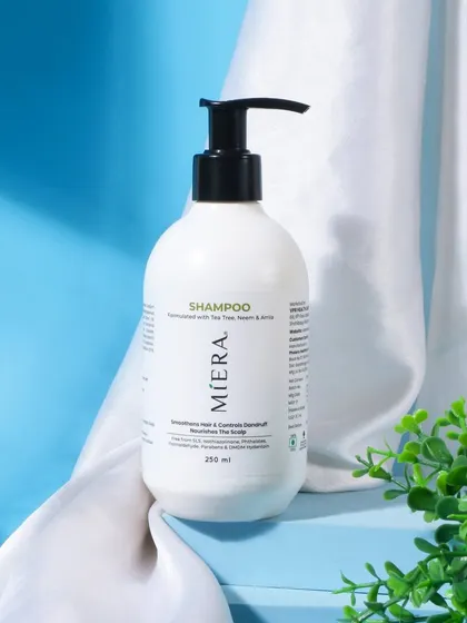 This shampoo is styled with a clean, white satin cloth against a fresh blue background. This composition gives the product a feeling of purity, softness, and freshness.