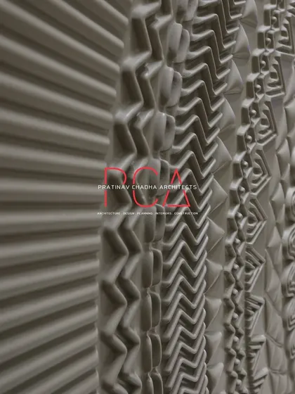 A detailed, angled shot of the CNC-carved main door at The Cursive Abode, highlighting the intricate geometric and tribal patterns.