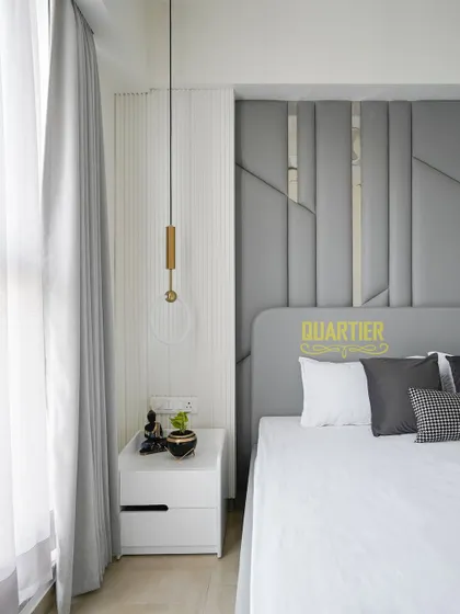 A close-up showing the interplay of light and texture by the window in the guest bedroom. The sheer curtains diffuse the natural light, creating a soft and calming ambiance.