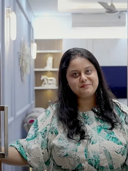 A happy client, Anandmayee, opening the door to her beautifully designed home. Her smile reflects the success of the project.