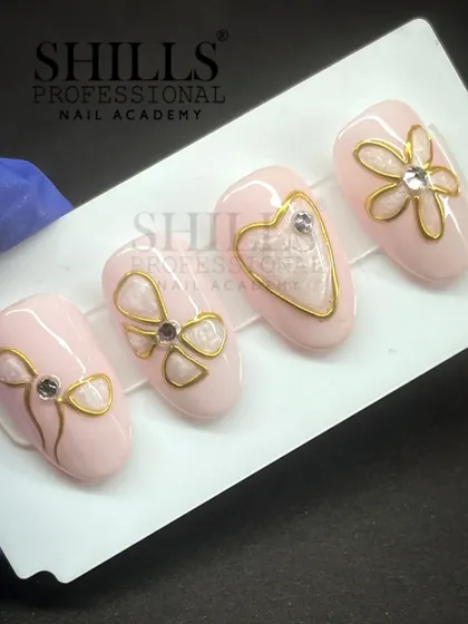 A delicate and feminine design featuring a soft pink base with hand-drawn gold bows, hearts, and flowers, each accented with a single rhinestone.