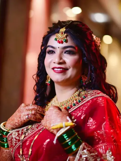 A candid moment of bridal beauty. The rich red of her outfit and the sparkle of her jewellery are enhanced by a warm, glowing makeup look.