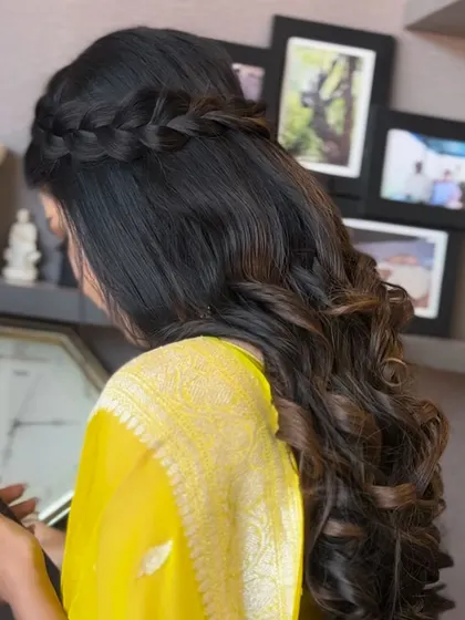 A beautiful half-up style with a waterfall braid and soft, cascading curls. This is a romantic and popular choice for many occasions.