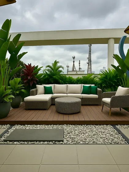 A 3D concept for a modern terrace with a raised deck, comfortable seating, and a border of white pebbles, all surrounded by lush tropical plants.
