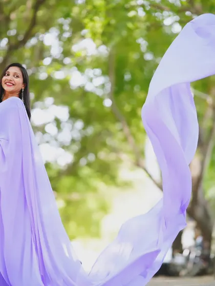 The sheer, lightweight fabric of the lavender trail saree is highlighted as it catches the light.