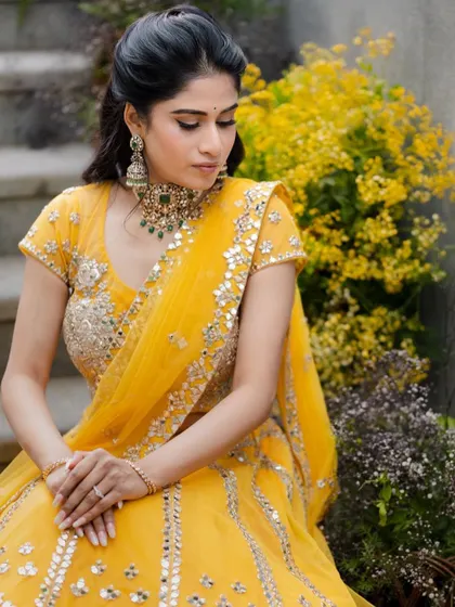 A serene portrait showcasing the soft glam makeup against a backdrop of yellow flowers, perfect for a Mehendi event.