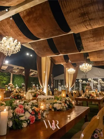 Inspired by rustic barn weddings, this dining space features warm, earthy tones. I used rich brown velvet drapes on the ceiling and elegant wooden tables adorned with floral runners to create a cozy and inviting atmosphere for a winter wedding.
