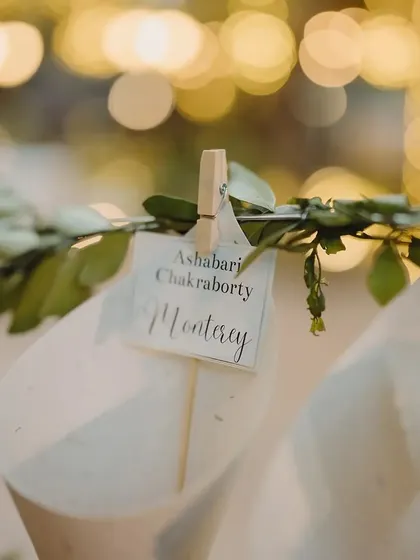 A creative way to guide guests to their seats. We designed these charming paper cones filled with petals, each with a personalized tag indicating the guest's name and their table, which was named after a city the couple had traveled to together.