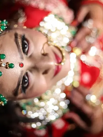 A top-angle portrait of a bride, emphasizing her stunning green and gold matha patti and jewelry. This perspective offers a unique and captivating view of the bridal adornments.