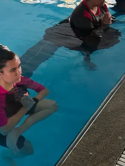 A close-up of participants in the pool, focused and present. Aqua yoga encourages a deep connection to the breath and the sensation of water on the skin.