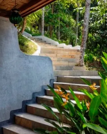 Stone and concrete steps wind their way up through the lush landscaping at Jalakara, connecting different parts of the property.