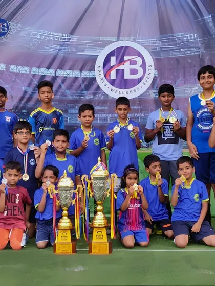 A team of our young athletes proudly displays their medals and trophies after a successful tournament. These achievements are a testament to their skill and dedication.