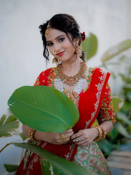 A playful and unique portrait using a large leaf as a prop. This adds a touch of creativity and fun to the bridal session while complementing the natural setting.