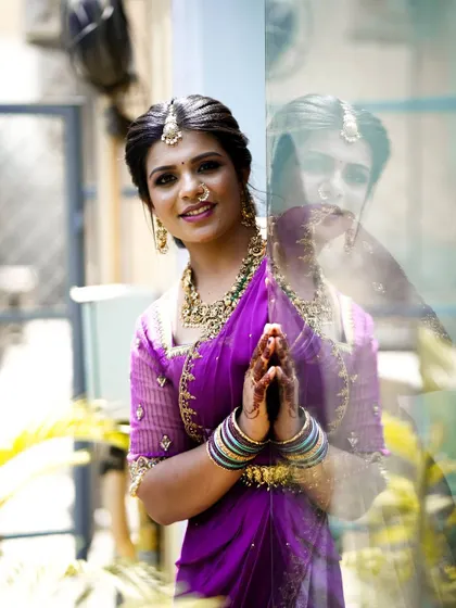 The sheer embroidered sleeves and rich purple color of the blouse create a beautiful contrast with the lighter, patterned skirt. This look is a testament to how we can mix and match elements to create something truly special from an old saree.