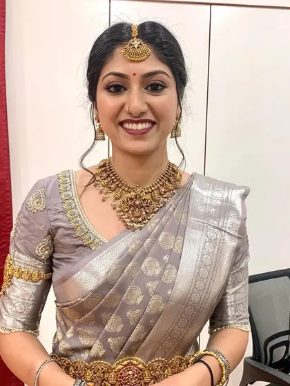 A classic South Indian look with a beautiful grey and silver Kanjeevaram saree. The makeup is kept clean and elegant to match the sophisticated attire.