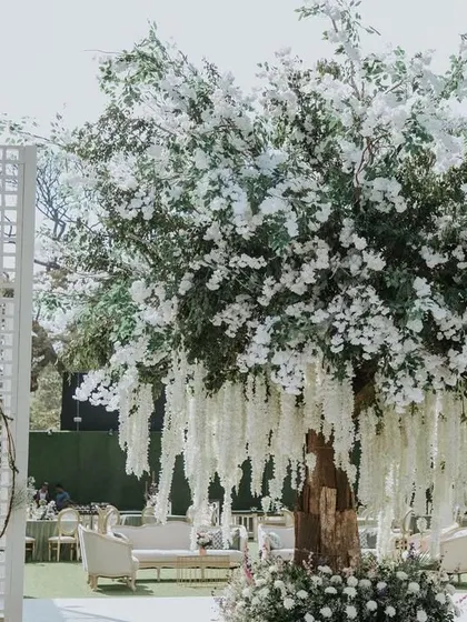 A chic daytime reception centered around a magnificent floral tree. I believe in creating unique focal points that are not only beautiful but also serve as a natural gathering spot, making your celebration feel both grand and intimate.