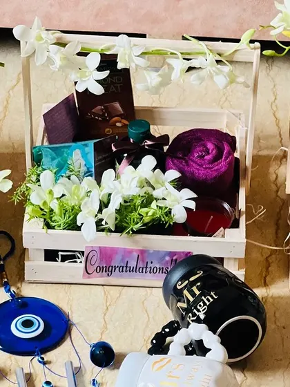 A closer view of the corporate wedding hampers, showing the mix of fresh orchids, towels, and other gifts inside the crates.
