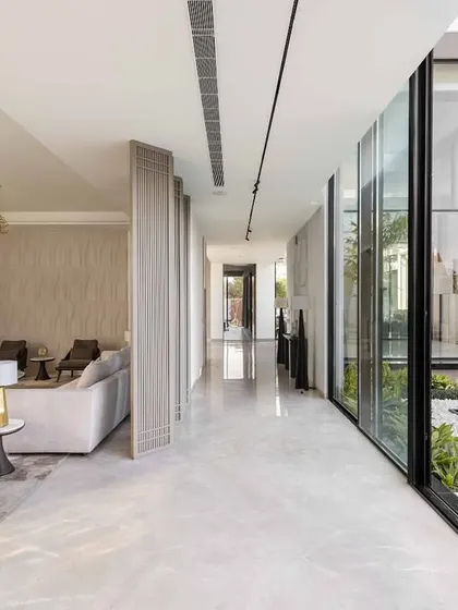 Another view of the glass-walled corridor, showcasing the seamless flow between the indoor living area and the outdoor courtyard. We believe in creating homes where you never have to choose between comfort and a connection to nature.