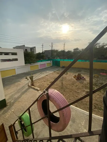 A view of our play yard from the stairs, showing the tires and open space under a sunny sky.