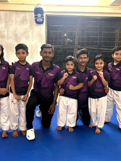 Our team, united and strong. Coaches and students pose together in our academy's official t-shirts, representing the Fit and Fight family.