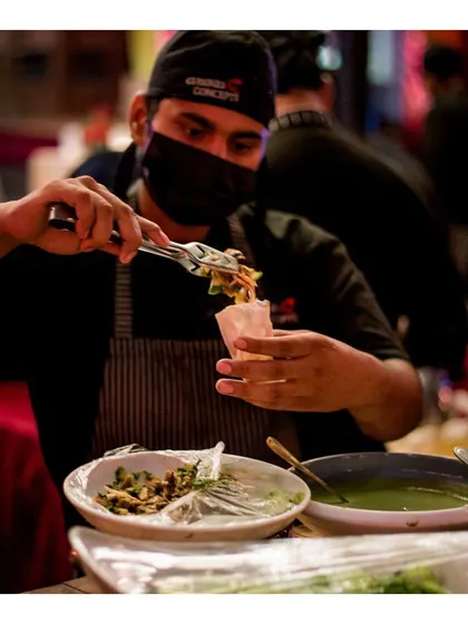 A chef preparing our innovative Goan poee pockets, stuffing the fresh bread with a choice of delicious fillings at a live counter.