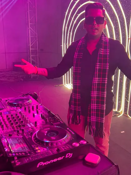 Posing for a photo behind the decks. I bring a positive and energetic presence to every event I play.
