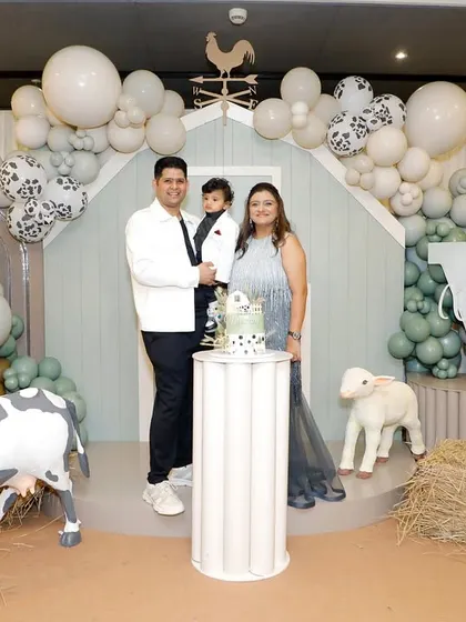 The happy family celebrating Vyom's first birthday in front of the beautiful farm-themed backdrop I designed.