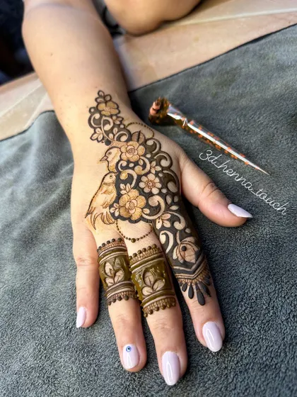 The charming bird and flower design, shown with the henna cone. This is a unique and artistic choice for any celebration.