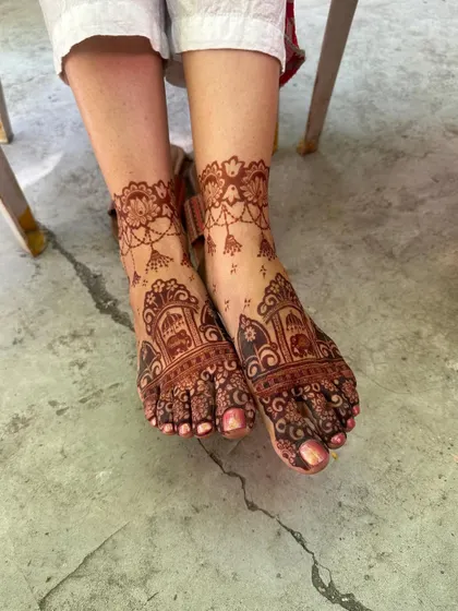 A full view of the stained bridal feet mehendi.