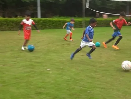 Action shot of older boys dribbling during a practice game, showcasing their developing skills and speed.
