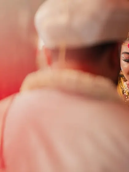 An artistic shot of a wedding ritual, with a soft red flare adding a creative and emotional touch to the scene.