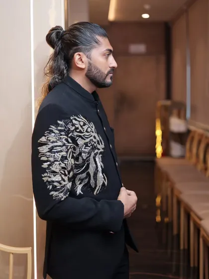 Another look at the black Jodhpuri suit, showing how the embroidery catches the light and adds a touch of metallic shimmer.