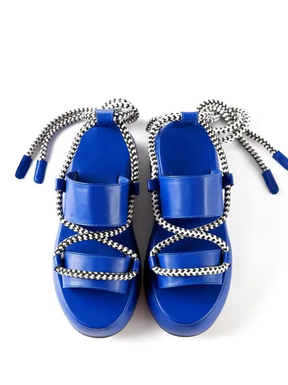 A clear, top-down e-commerce photograph of Jeetinder Sandhu's blue platform sandals on a pure white background. This angle provides a full view of the shoe's design, perfect for a primary product listing image.