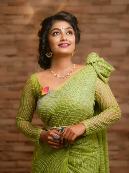 A portrait of an actress in a beautiful light green designer saree. This is a great example of a collaboration with a designer and makeup artist.