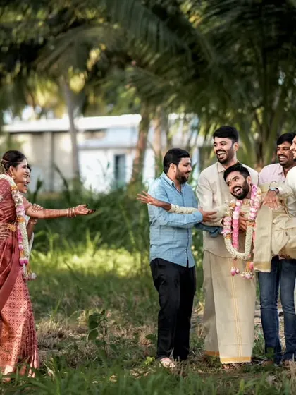 The groom's friends playfully carrying him away from the bride, a hilarious candid moment from a Palladam wedding.