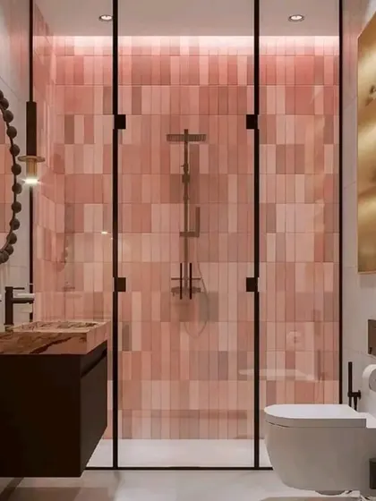 A bold and beautiful bathroom featuring pink subway tiles in the shower area, a dark wood vanity, and a unique decorative mirror.