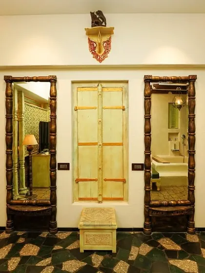 This shot captures the entryway's symmetry, featuring ornate carved mirrors and a traditional door that sets the vintage tone for the entire suite. Architectural details are a key part of my focus.