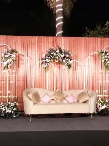 The full stage setup, showing how the combination of a shimmering backdrop, modern structural elements, and lush florals creates a perfect photo opportunity and a beautiful focal point.