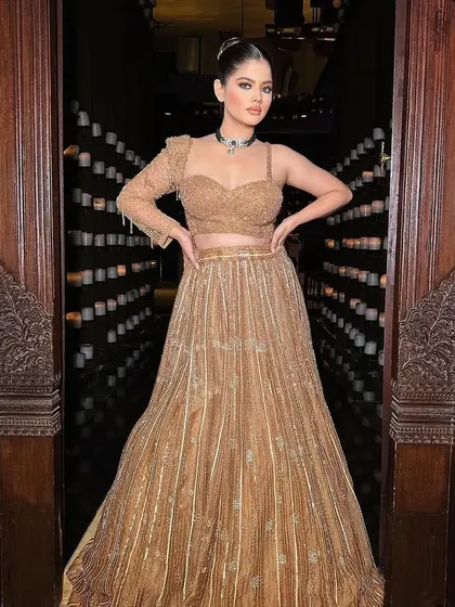Presenting Gazal. A golden, shimmering lehenga-style gown, perfect for a cocktail or reception.