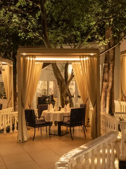 A single cabana illuminated at dusk, nestled among the trees. This setting offers a quiet escape for a peaceful meal.
