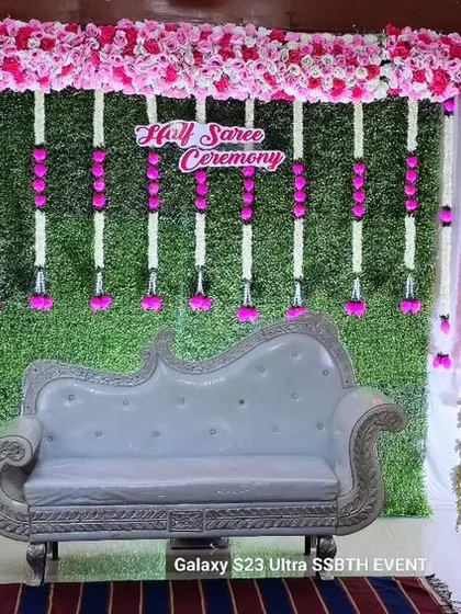 I created this elegant stage for a Half Saree Ceremony using a lush green wall backdrop. To complete the look, I added hanging floral garlands, a classic white diwan sofa, and decorative bird cages on pedestals, creating a perfect photo spot.