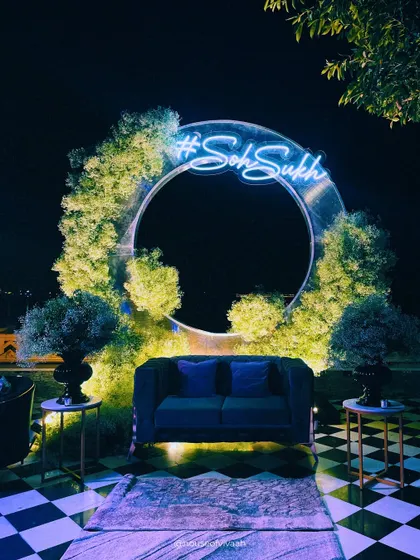 A modern and personalized photo-op. This circular installation, framed with greenery and a custom neon hashtag, provides a chic and interactive spot for guests to capture memories.