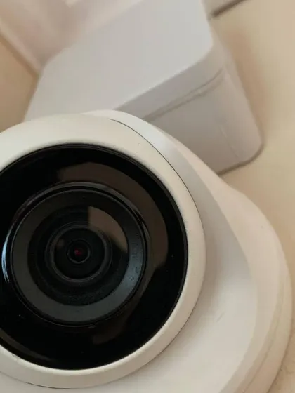 A close-up view of a smart indoor camera lens. These compact cameras are powerful, offering wide viewing angles and clear HD resolution to capture every detail.