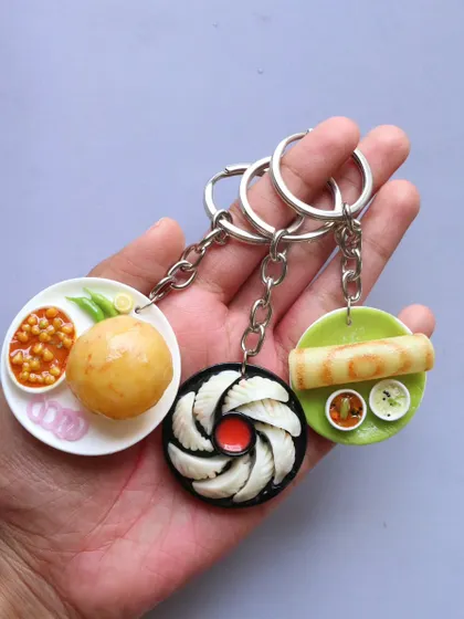 A set of three popular food keychains: chole bhature, momos, and dosa.