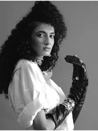A classic black and white portrait from a FAD International shoot. The model's expressive gaze, voluminous hair, and embellished glove create a timeless and elegant fashion image.